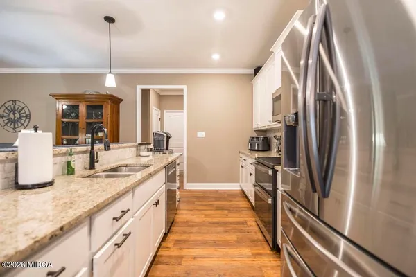 a kitchen with stainless steel appliances granite countertop a refrigerator and a sink