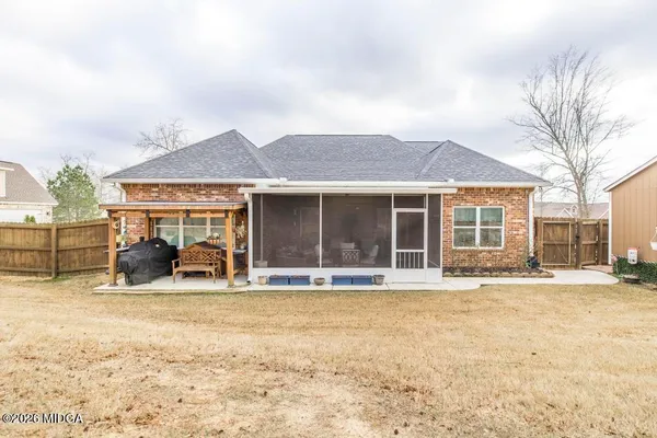 a front view of house with yard and trees in the background
