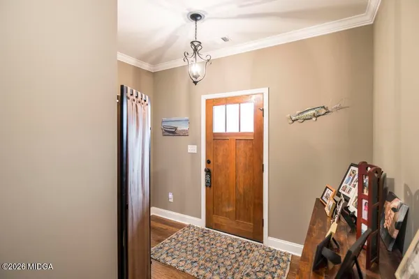 a view of a hallway with wooden floor and a livingroom
