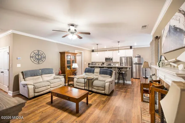 a living room with furniture kitchen view and a large window