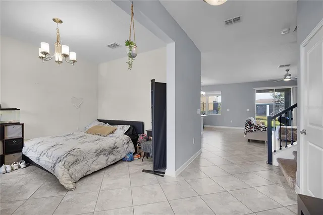 a spacious bedroom with a bed chandelier and bathroom