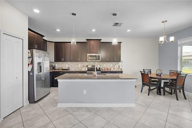 a large kitchen with kitchen island a sink a counter and a dining table