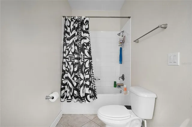 a white toilet sitting next to a shower curtain