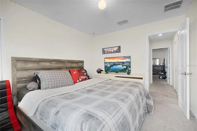 a bedroom with a large bed and a chandelier