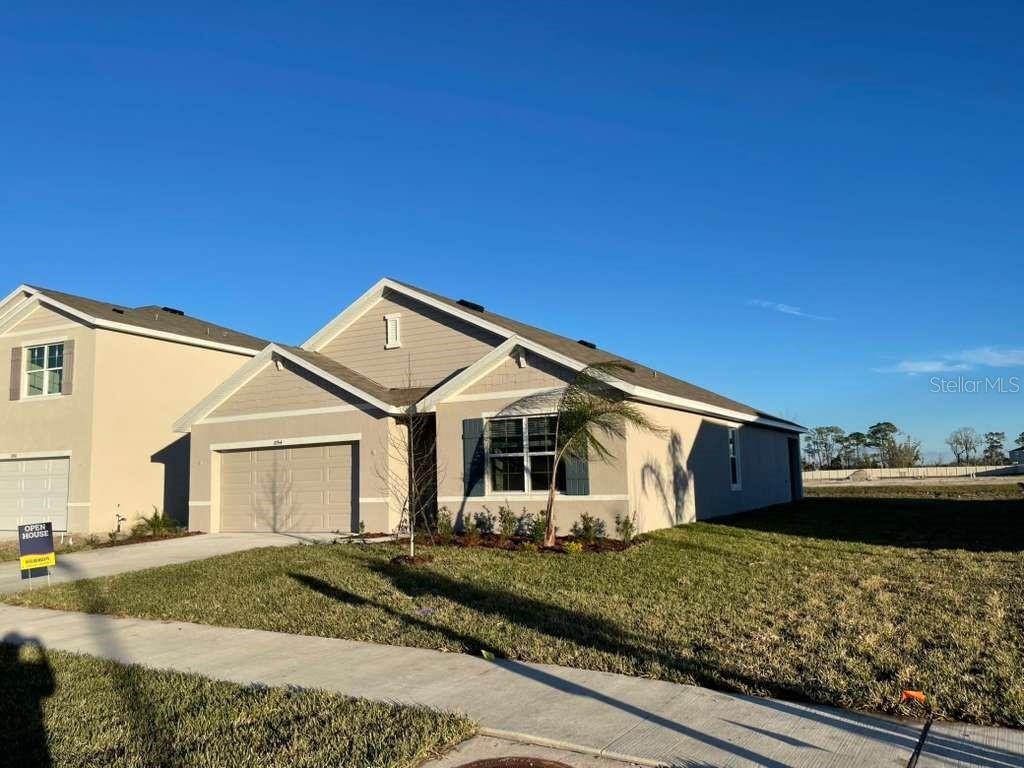 8954 Forge Breeze Loop Wesley Chapel, FL 33545 - Photo 2 of 37 a front view of a house with a garden