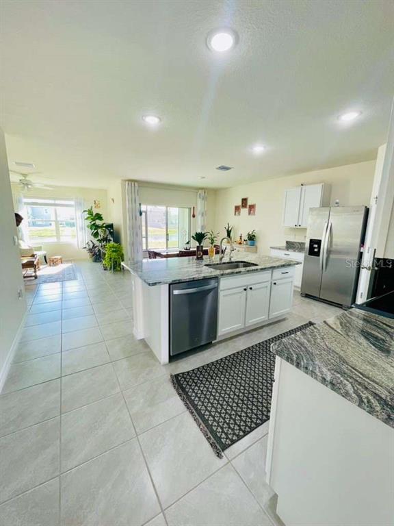 8954 Forge Breeze Loop Wesley Chapel, FL 33545 - Photo 5 of 37 a large kitchen with a stove a sink a counter top space and appliances