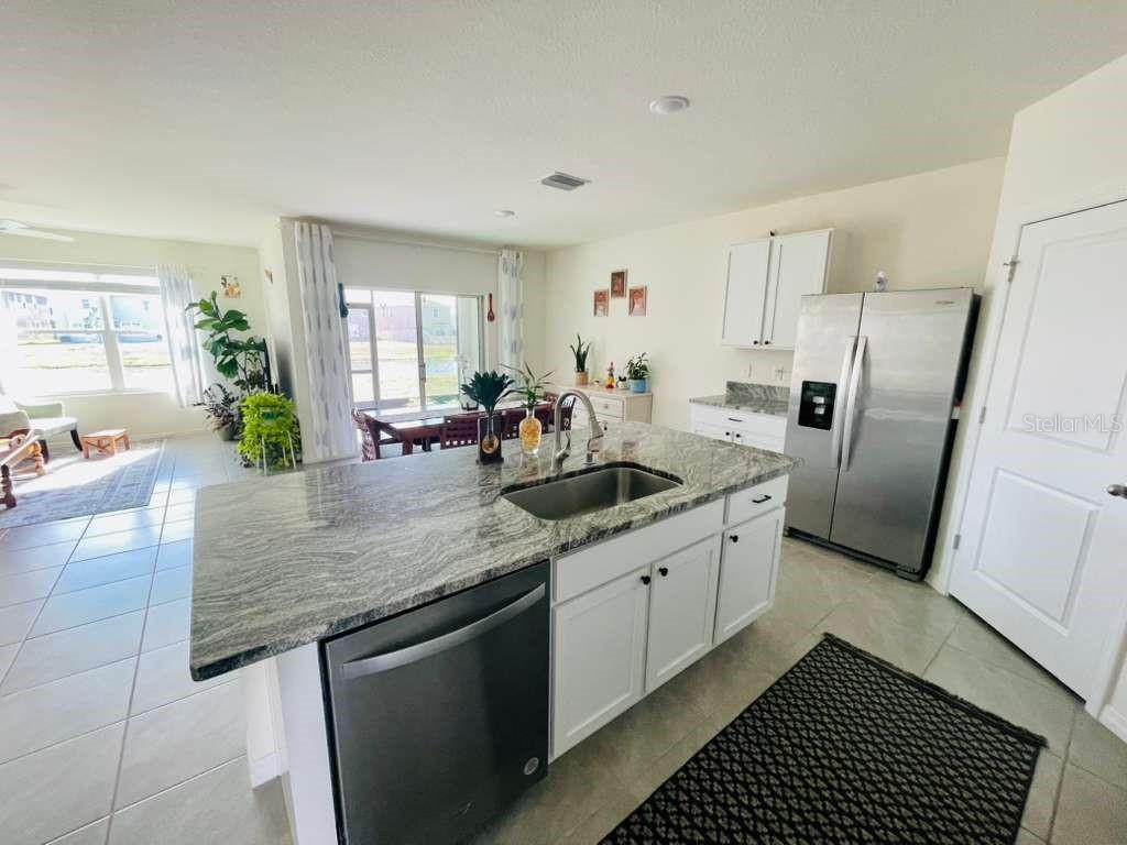 8954 Forge Breeze Loop Wesley Chapel, FL 33545 - Photo 6 of 37 a kitchen with stainless steel appliances granite countertop a sink stove and refrigerator