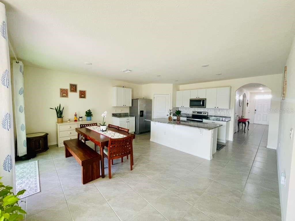 8954 Forge Breeze Loop Wesley Chapel, FL 33545 - Photo 7 of 37 a living room with furniture and kitchen view