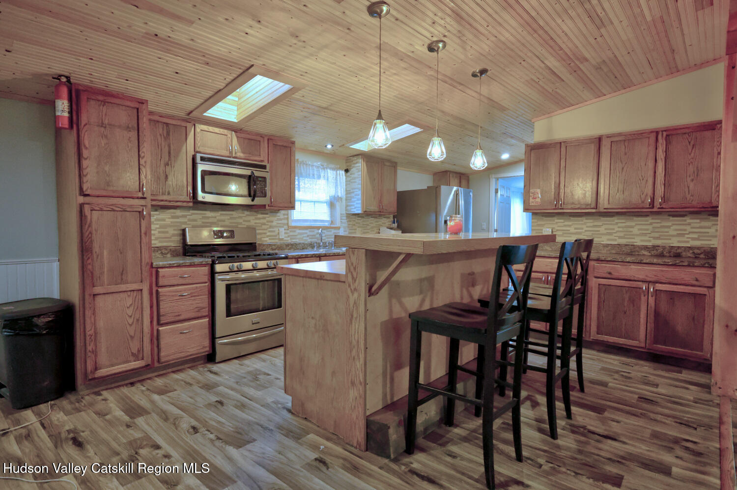 141 Jones Road Round Top, NY 12473 - Photo 13 of 70 a kitchen with kitchen island granite countertop wooden floors and stainless steel appliances