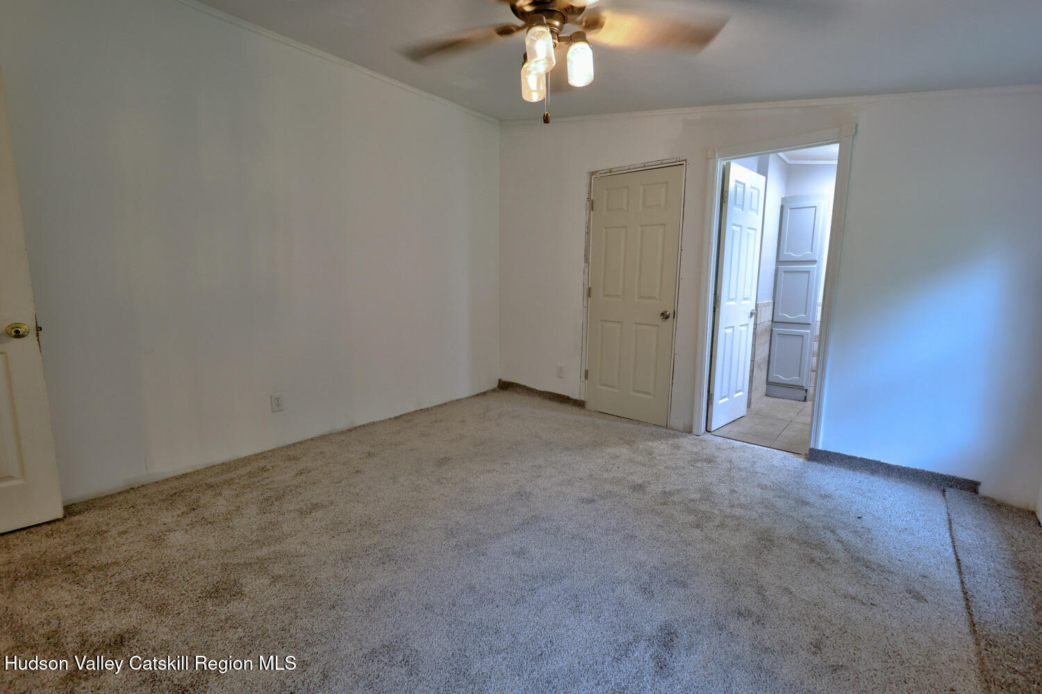 141 Jones Road Round Top, NY 12473 - Photo 39 of 70 an empty room with a chandelier fan and windows