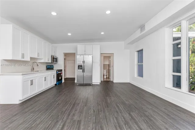 a kitchen with stainless steel appliances a refrigerator and wooden floor