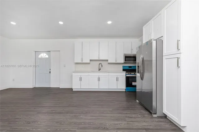 a view of kitchen with wooden floor and electronic appliances