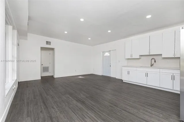 a view of a kitchen with wooden floor and electronic appliances