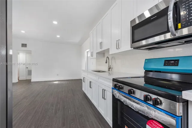 a kitchen with stainless steel appliances granite countertop a stove and a microwave