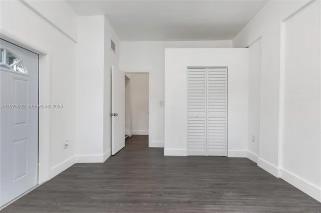 an empty room with wooden floor & windows