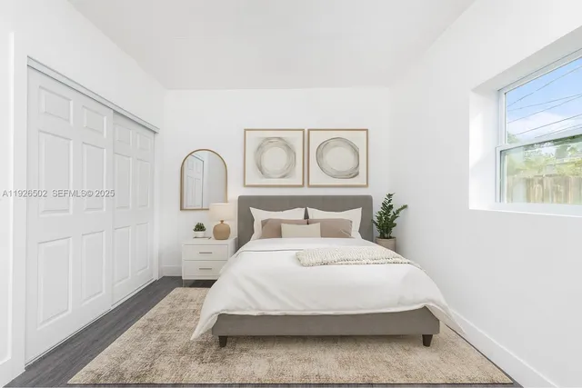 a bedroom with a large bed and wooden floor