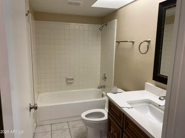 an empty room with wooden floor closet and windows