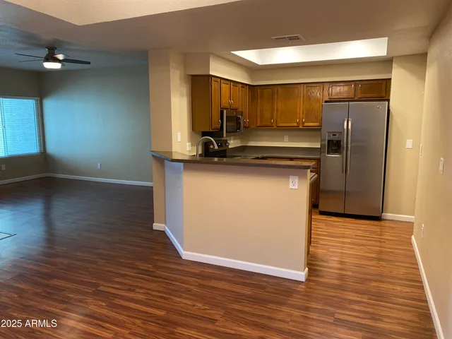 a view of an empty room with wooden floor and a fireplace