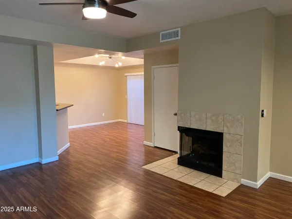 an empty room with wooden floor and fireplace