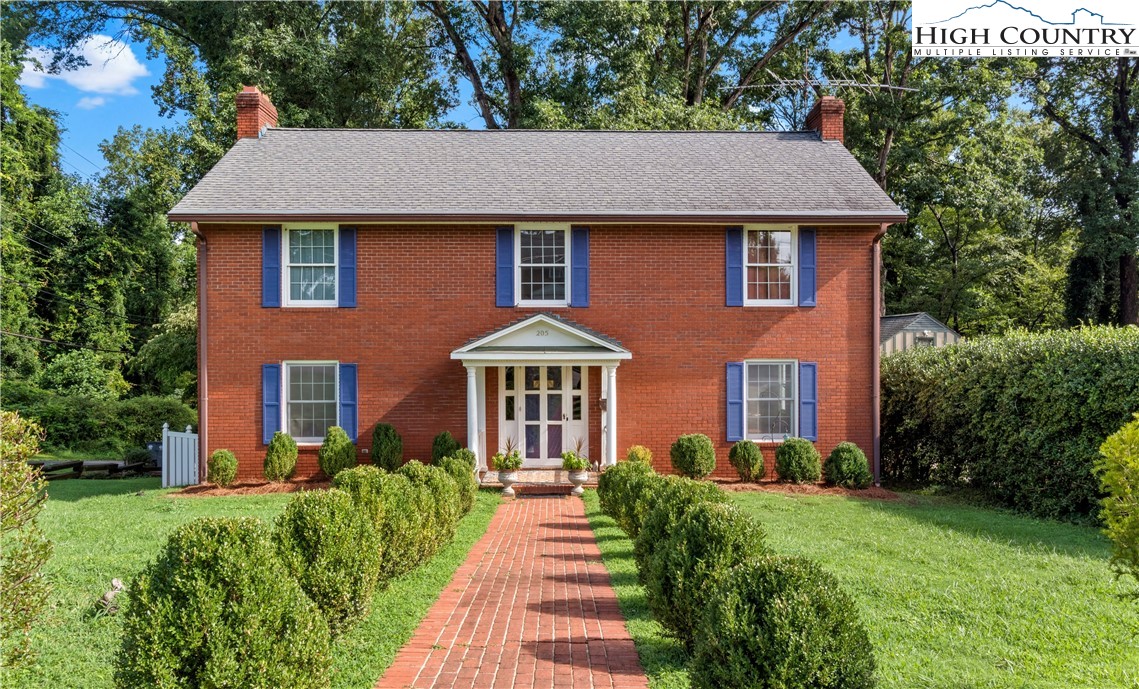 a front view of a house with a yard and trees
