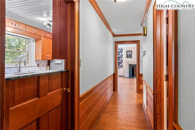 a view of a hallway with wooden floor and windows