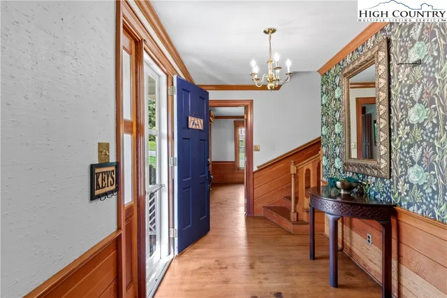 a view of a hallway with wooden floor and staircase