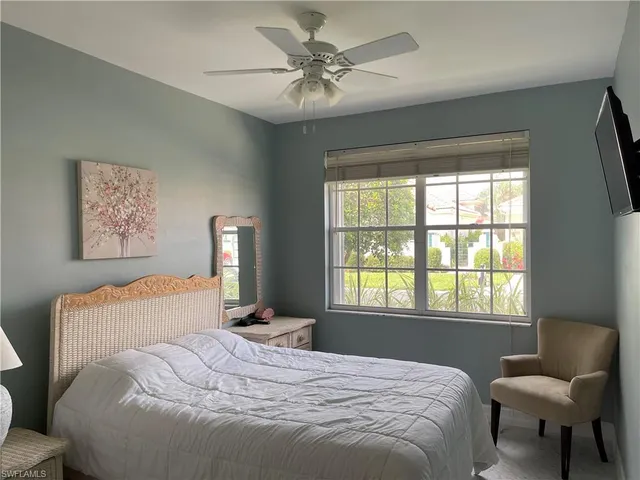 a bedroom with a bed and chair with window
