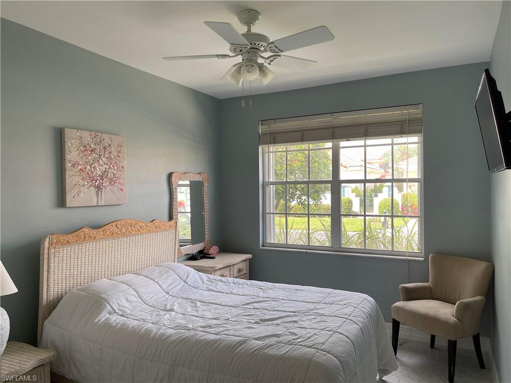 5950 Almaden Drive Naples, FL 34119 - Photo 13 of 22 a bedroom with a bed and chair with window