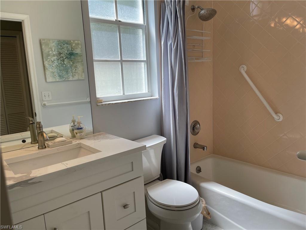 5950 Almaden Drive Naples, FL 34119 - Photo 15 of 22 a bathroom with a sink toilet vanity and tub