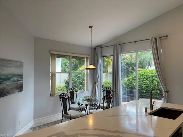 a dining room with large window chairs and front door