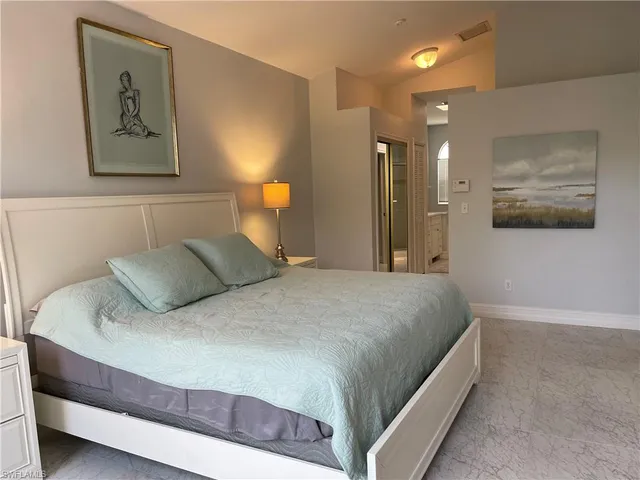 a bedroom with a bed and painting on the wall