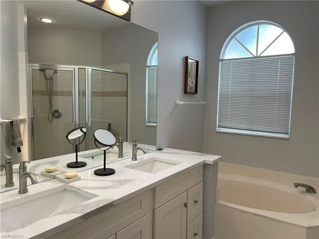 a bathroom with a granite countertop sink a mirror and shower