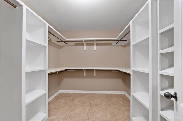 a view of walk in closet with empty racks