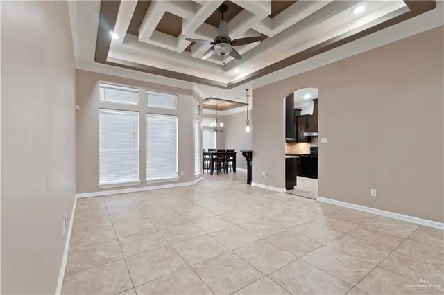 a view of an empty room with a window and a chandelier fan