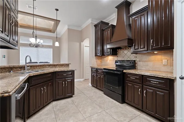 a kitchen with stainless steel appliances granite countertop wooden cabinets a stove top oven a sink and dishwasher