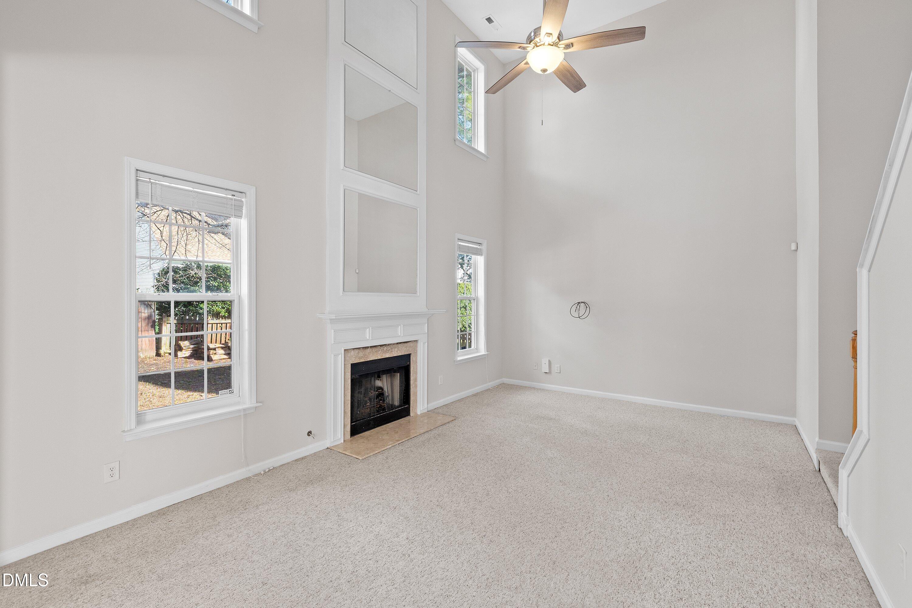 5717 Keowee Way Raleigh, NC 27616 - Photo 15 of 41 an empty room with windows fireplace and fan