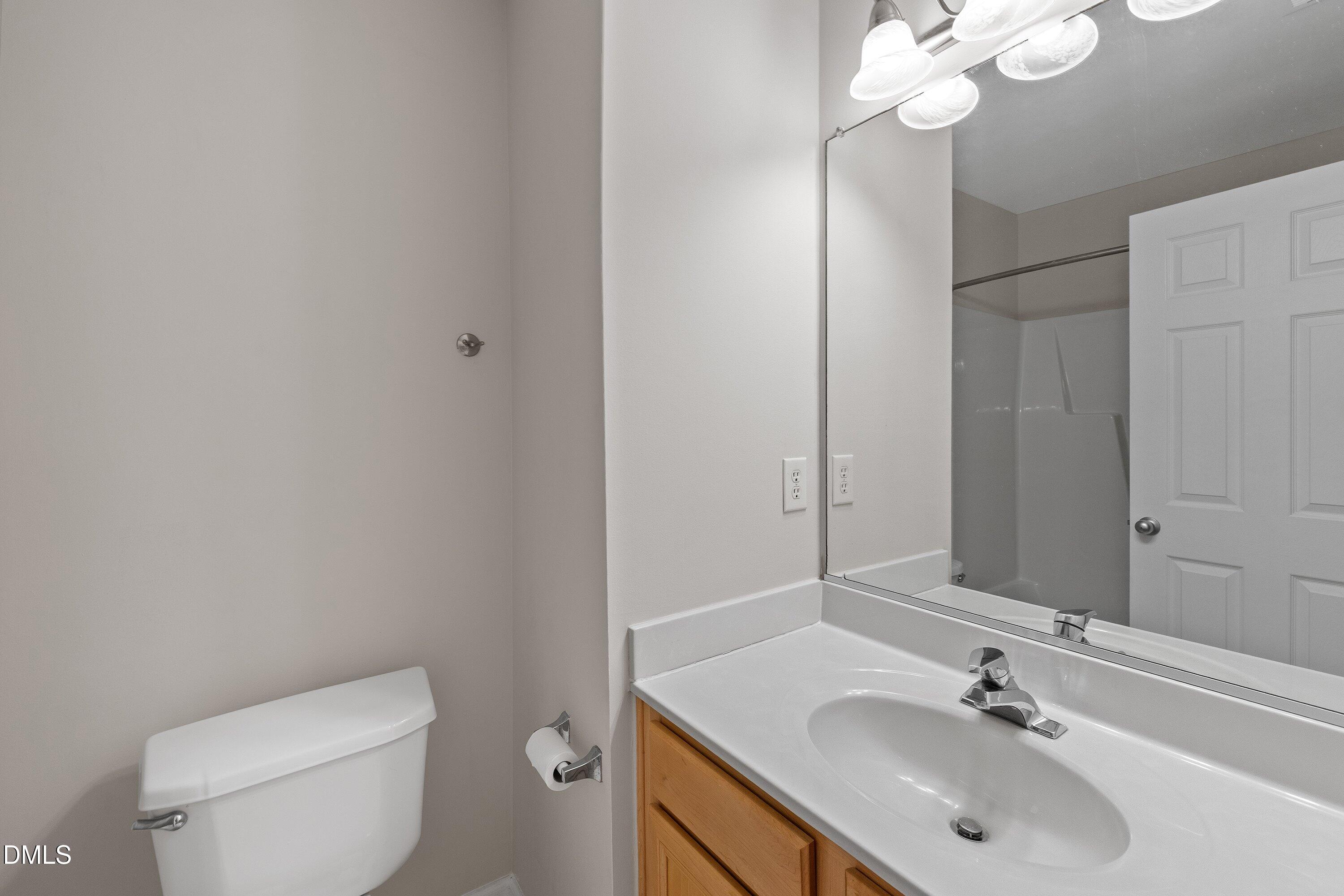 5717 Keowee Way Raleigh, NC 27616 - Photo 27 of 41 a bathroom with a sink a toilet and a mirror