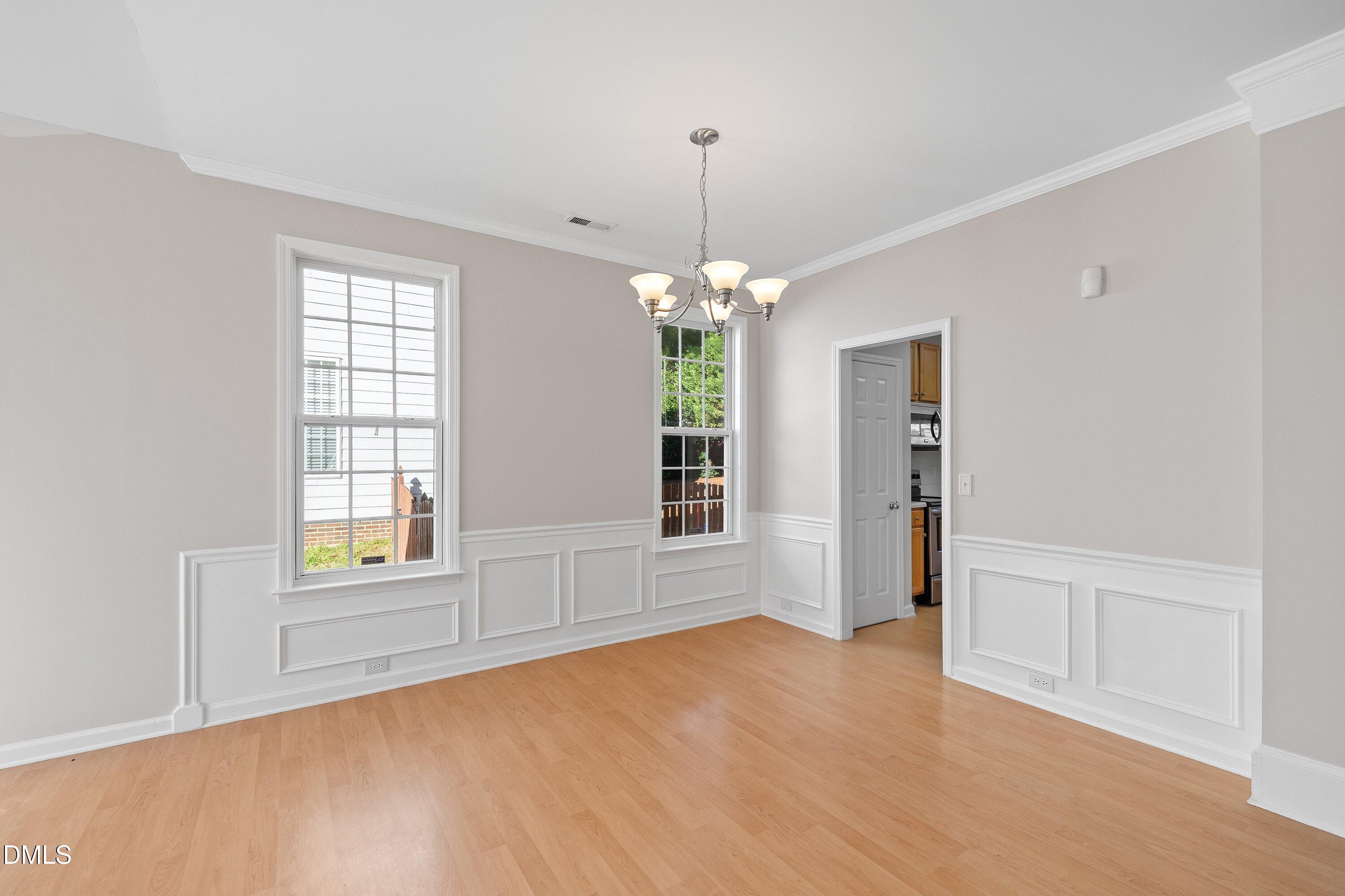5717 Keowee Way Raleigh, NC 27616 - Photo 5 of 41 an empty room with chandelier and windows
