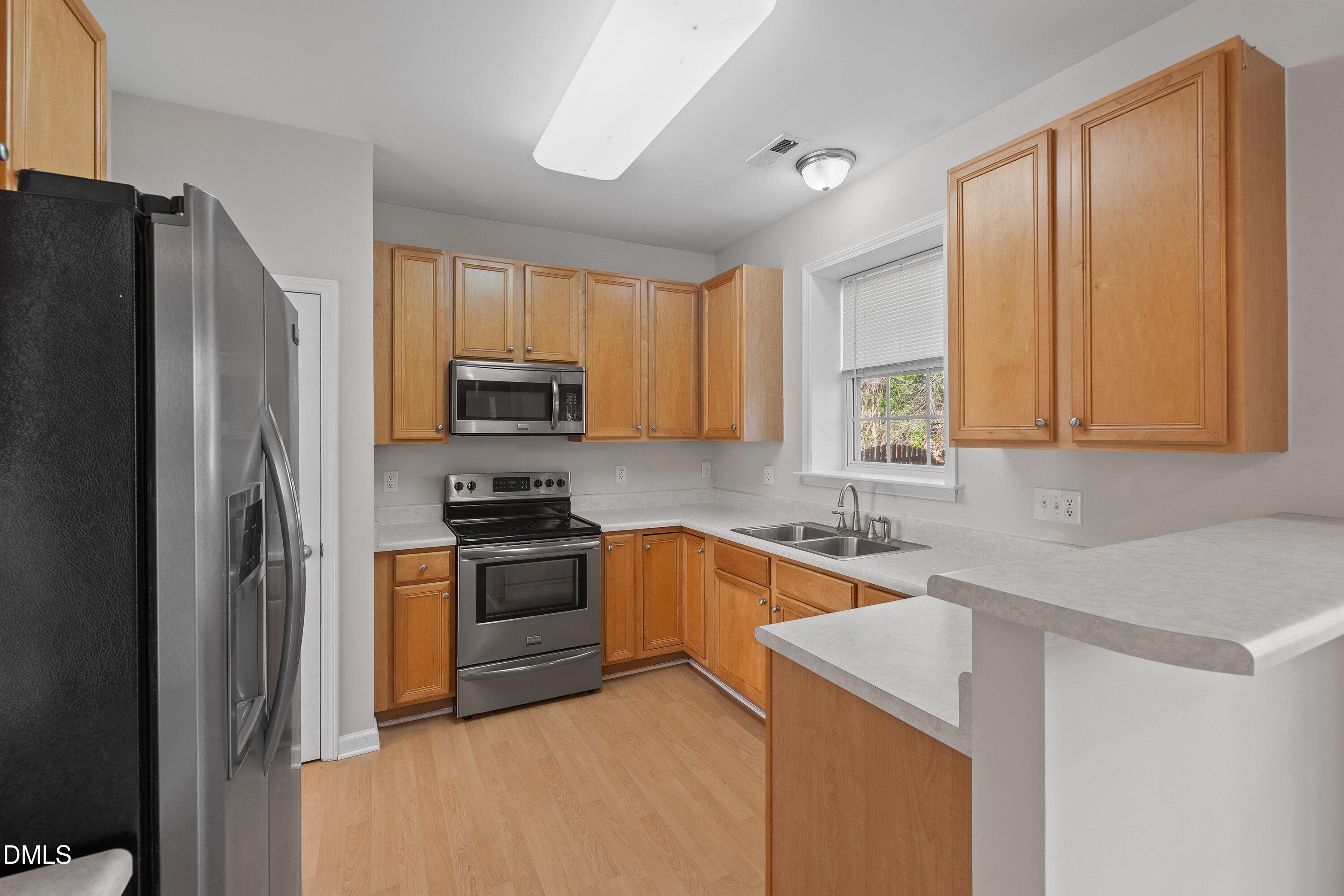 5717 Keowee Way Raleigh, NC 27616 - Photo 6 of 41 a kitchen with stainless steel appliances granite countertop a refrigerator stove and sink