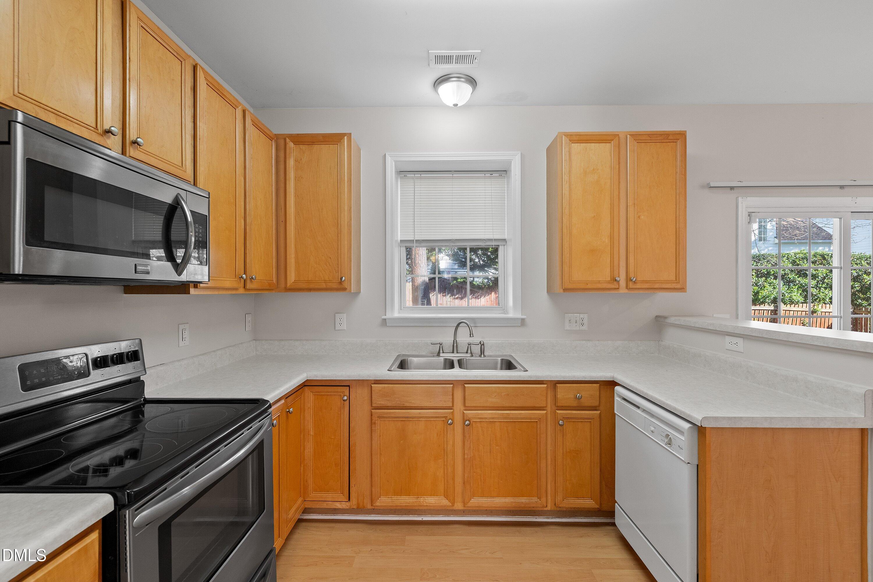 5717 Keowee Way Raleigh, NC 27616 - Photo 8 of 41 a kitchen with sink a microwave and cabinets