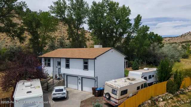 a white house covered with tall trees