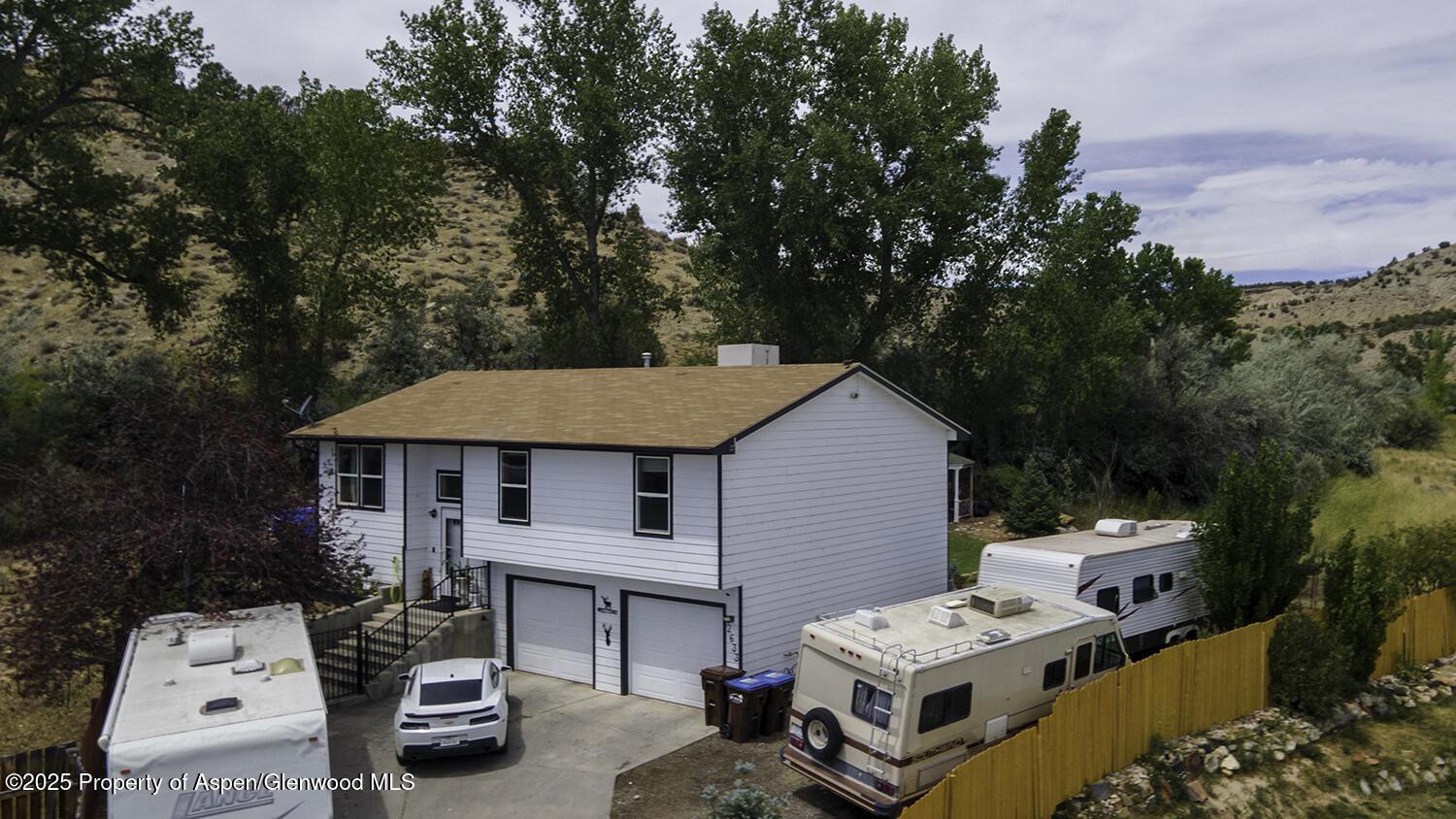 a white house covered with tall trees