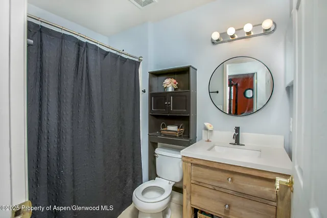 a bathroom with a toilet a sink and a mirror