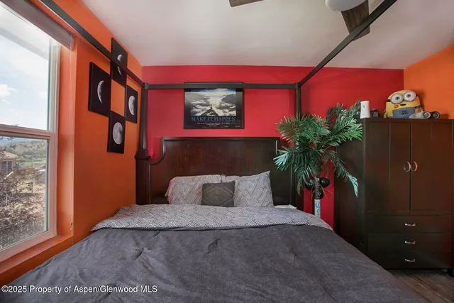a bedroom with a bed and a potted plant