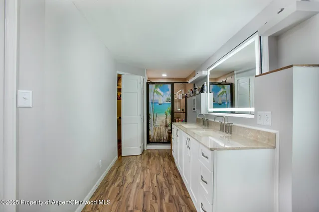a spacious bathroom with a granite countertop sink and a large mirror
