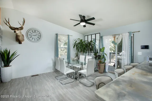 a view of a livingroom with furniture wooden floor a ceiling fan and a window