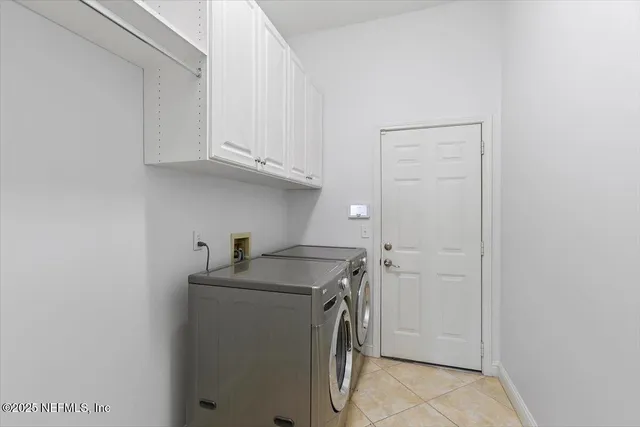 a utility room with cabinets washer and dryer