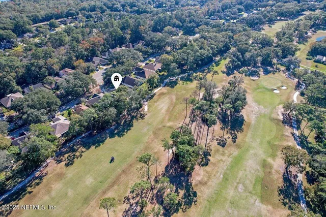 an aerial view of residential houses with outdoor space and trees all around