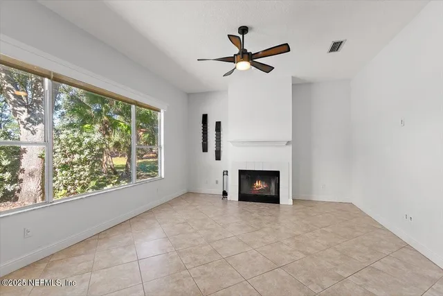 a view of empty room with fireplace and windows