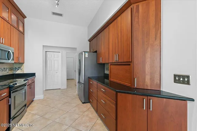 a kitchen with stainless steel appliances a refrigerator and a stove top oven